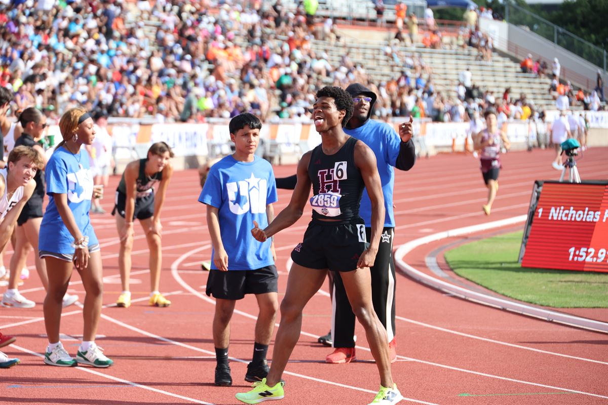Nicholas L. Ferguson with his Houston Heights coach moments after winning the 2026 UIL Texas 6A Boys 800m State Championship — scoreboard shows 1:52