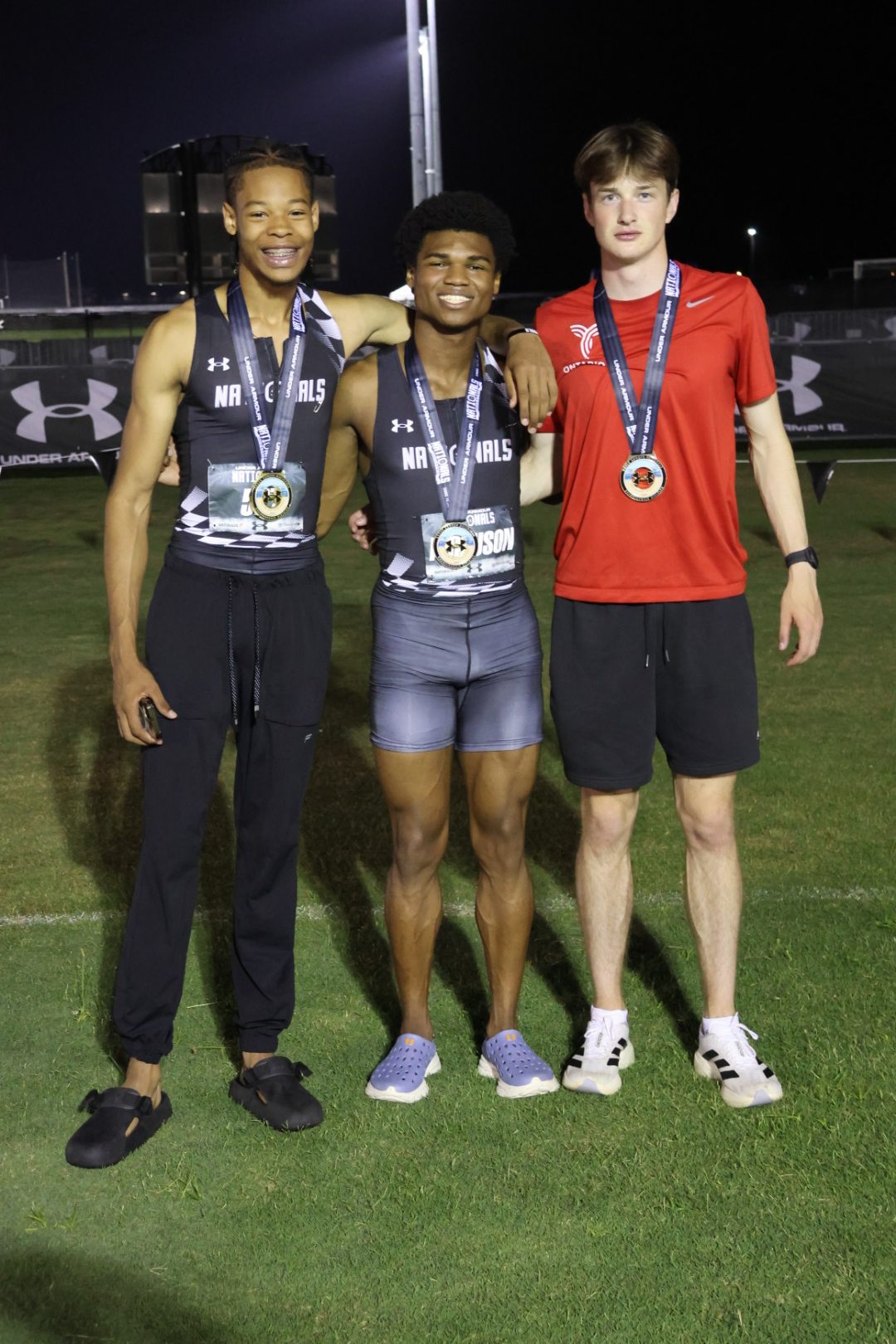 The three boys 800m medalists at the 2026 Under Armour Track & Field Nationals — champion Joshua Sharp, All-American runner-up Nicholas L. Ferguson and third-place Ryan Georgeson with their medals