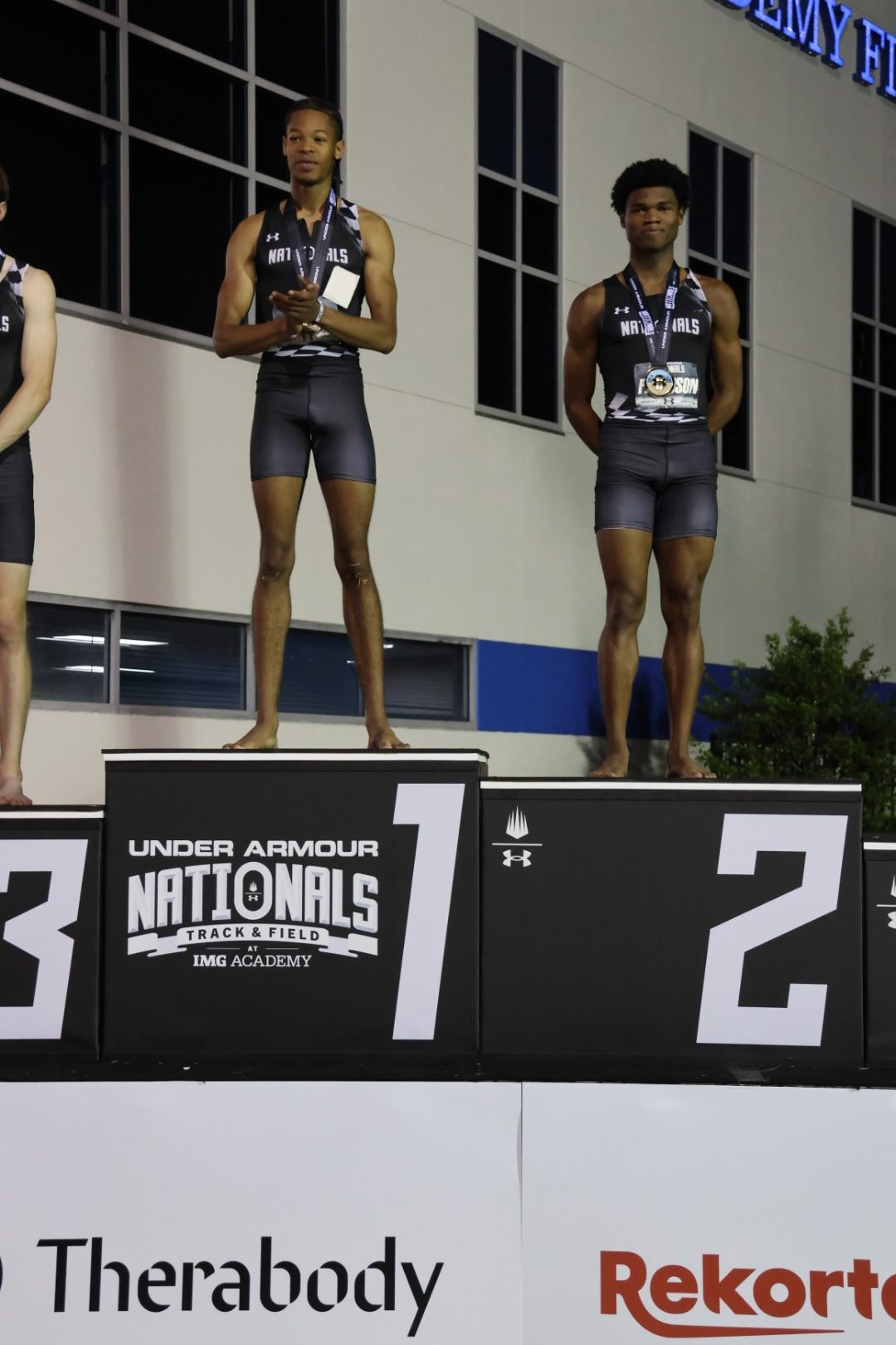 Nicholas L. Ferguson of Houston Heights High School on the runner-up podium beside champion Joshua Sharp after the 2026 Under Armour Nationals high school boys 800m final at IMG Academy